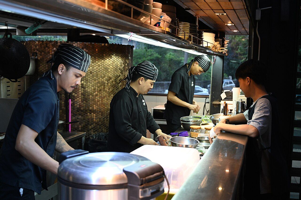 Brigade en cuisine derrière le passe